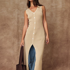 Woman wearing the Salt Air Rib Knit Midi Dress, a beige sleeveless rib knit button-front midi dress with a V-neckline and adjustable front slit.
