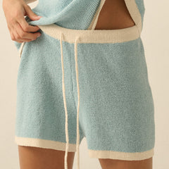 Light blue shorts with beige trim worn by a person on a plain background