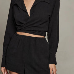 Black linen pull-on shorts with elastic waistband and side pockets, styled with neutral top.