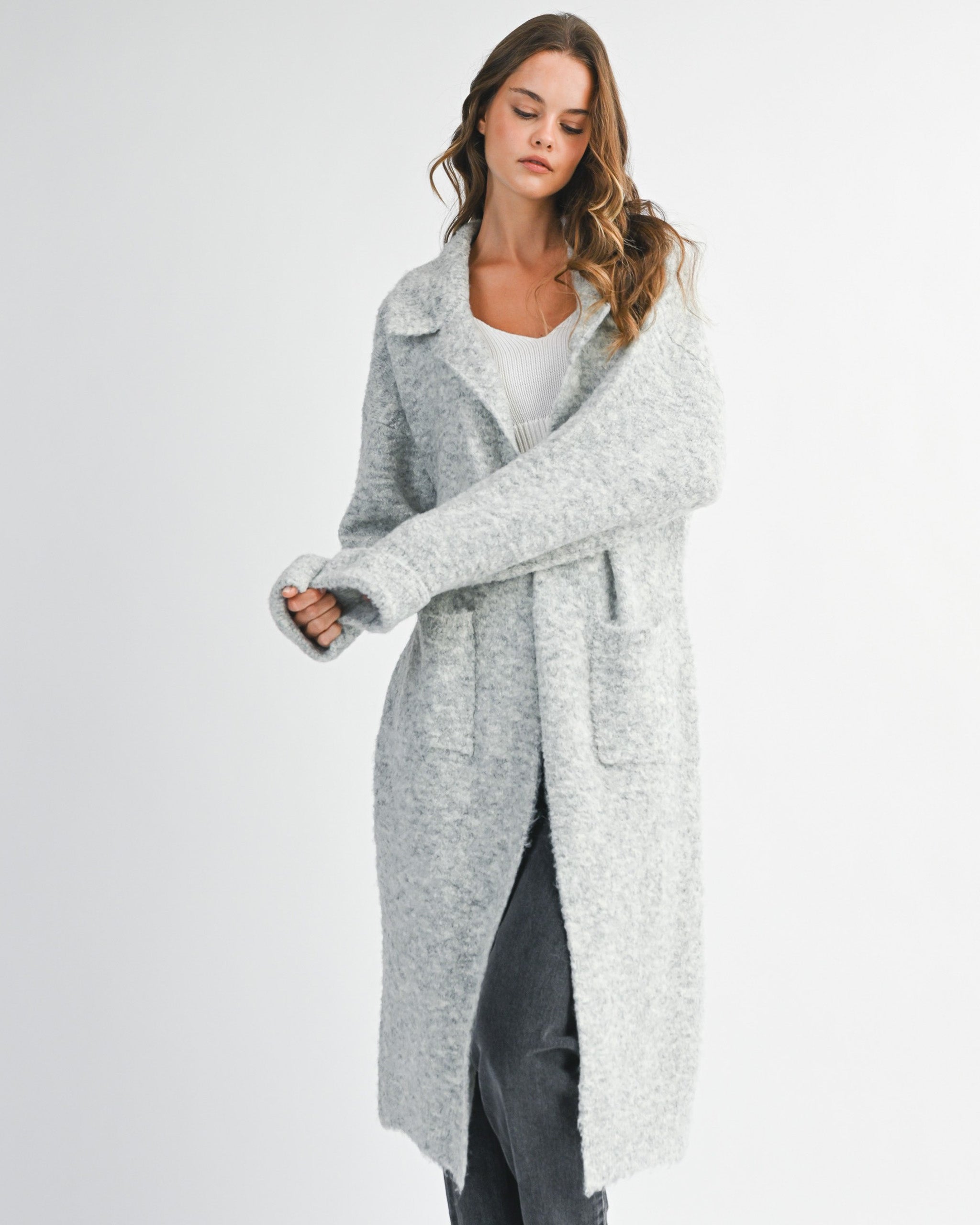 woman wearing long grey cardigan sweater with collared neckline