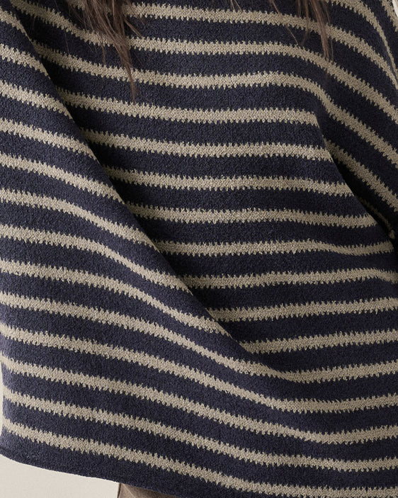 Close-up of a knit sweater with horizontal navy and gray stripes, showing the textured fabric and a small section of dark hair at the top.