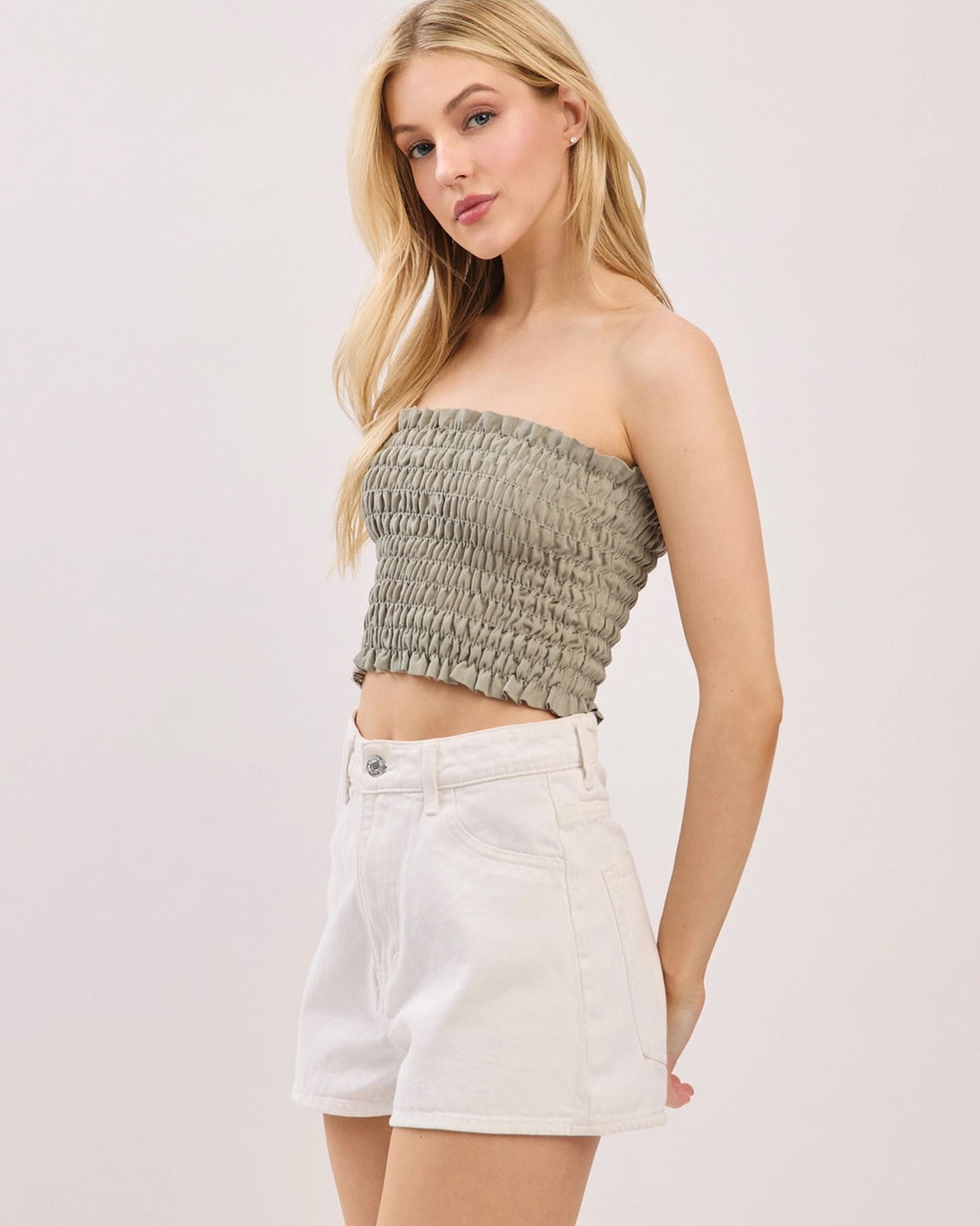 sage green smocked bandeau tube top with ruffle trim styled with denim shorts