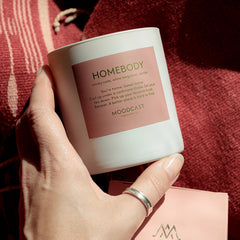 Luxury scented candle with smoky cade, vanilla, amber, and white bergamot in a cozy home setting