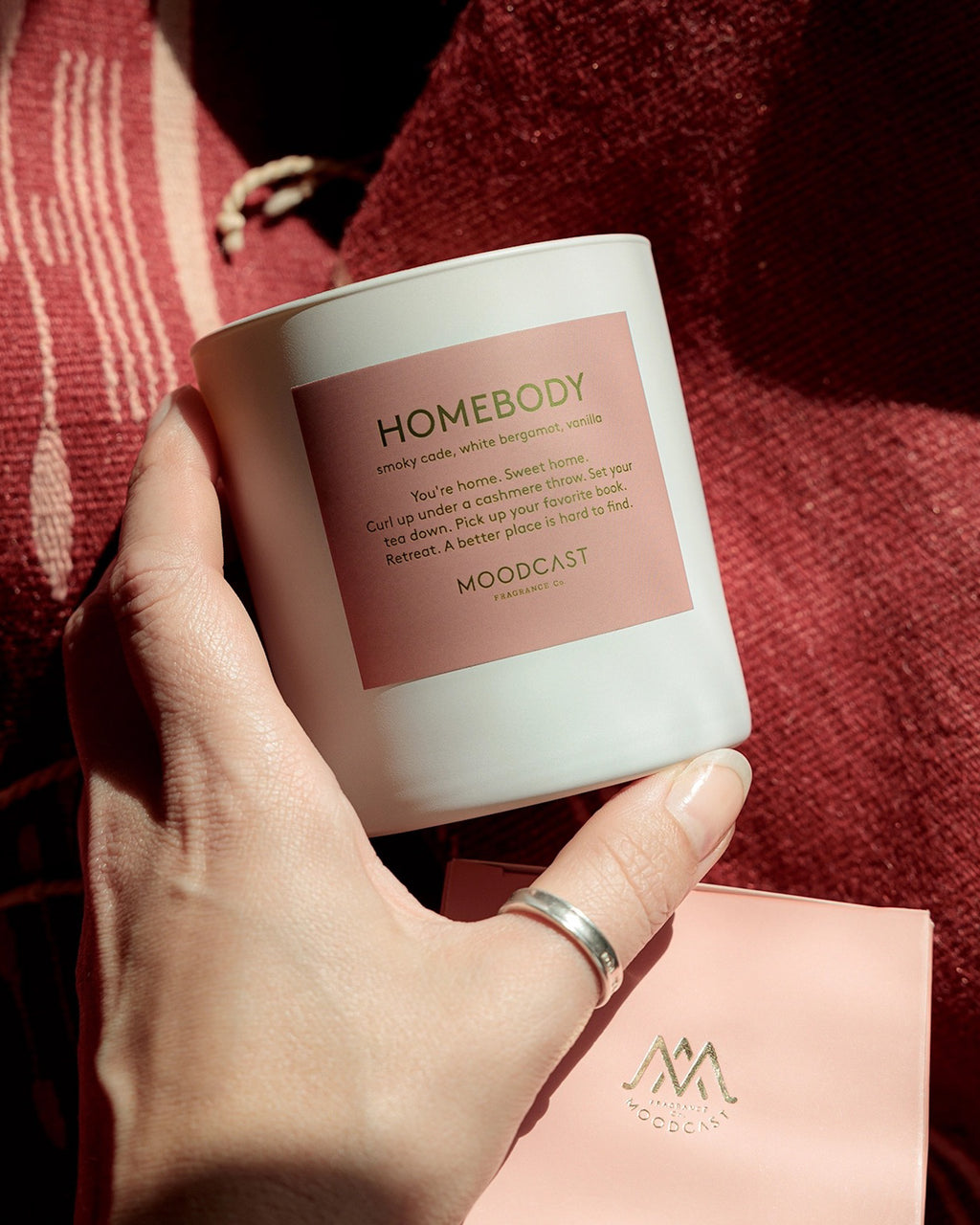 Luxury scented candle with smoky cade, vanilla, amber, and white bergamot in a cozy home setting