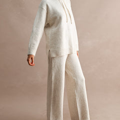woman wearing cream wide leg knit pants and matching hooded knit sweater