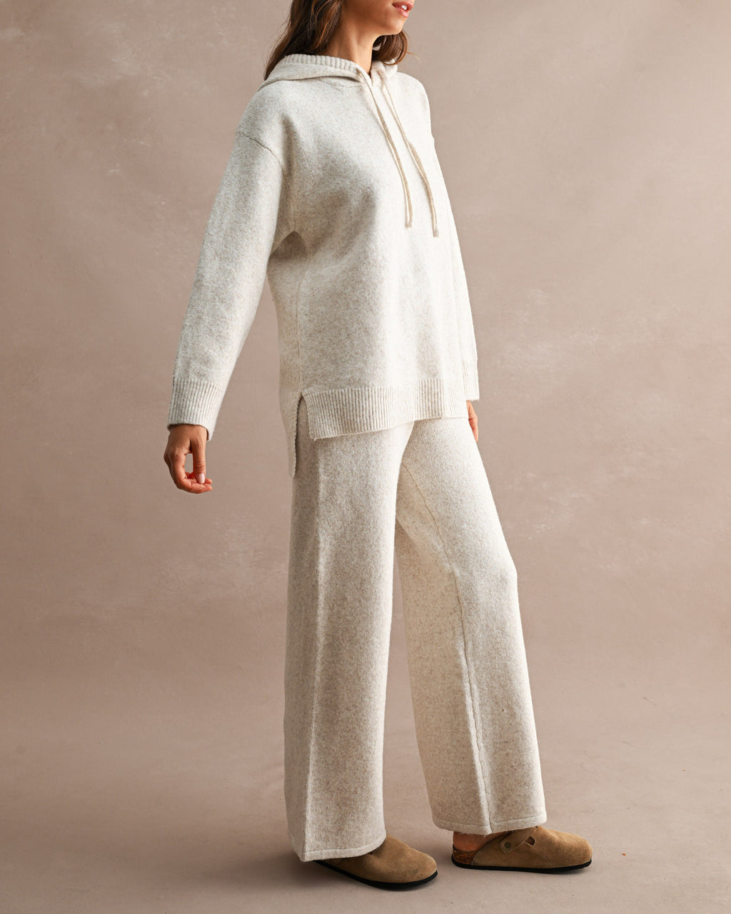 woman wearing cream wide leg knit pants and matching hooded knit sweater
