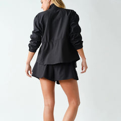 Women's lightweight black peplum active jacket with zip-up mock neck, adjustable waist, four-way stretch fabric, and relaxed athletic fit.